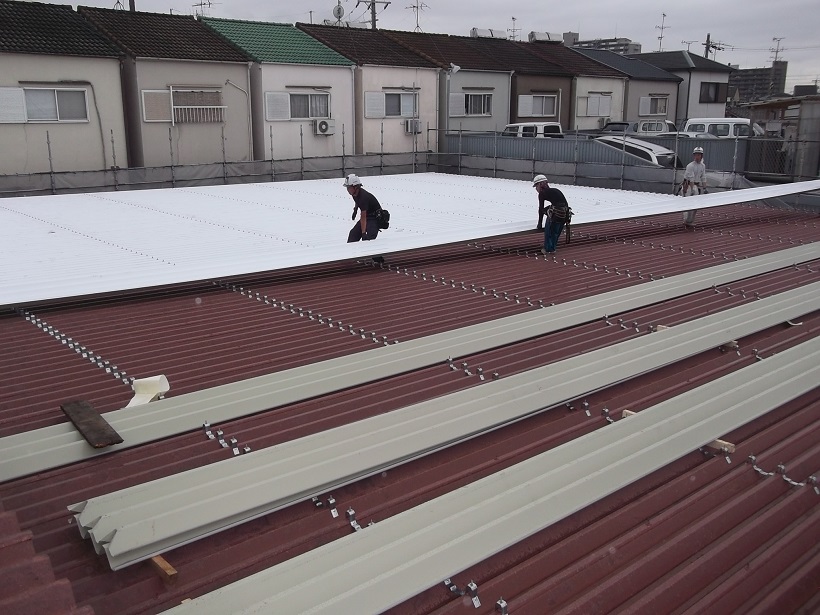 大阪府枚方市でショールームの屋根の大規模修繕工事で折板屋根の増し張りリフォームのリフォーム中の写真です。